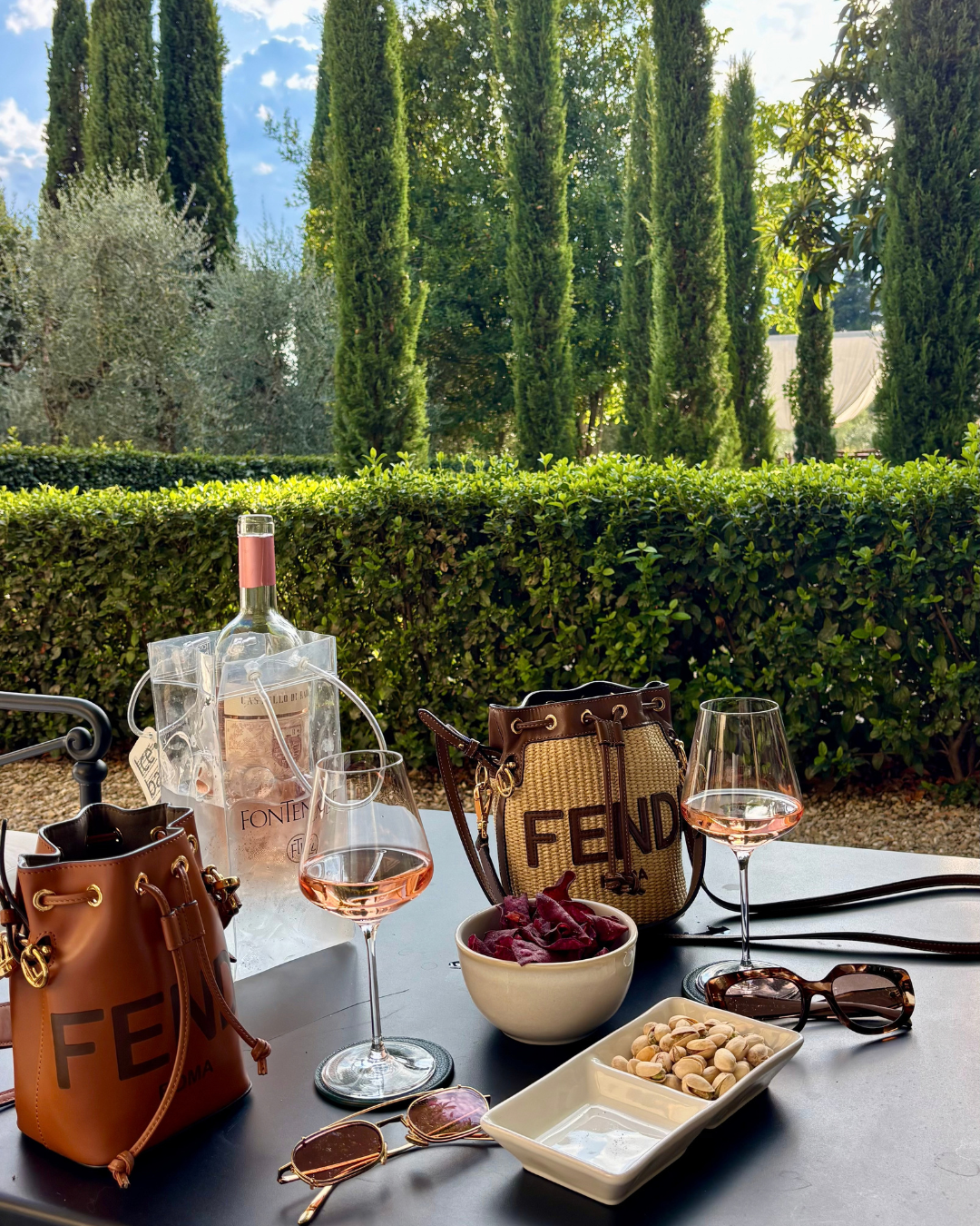 Rosé and aperitivo snacks in a cypress-lined garden
