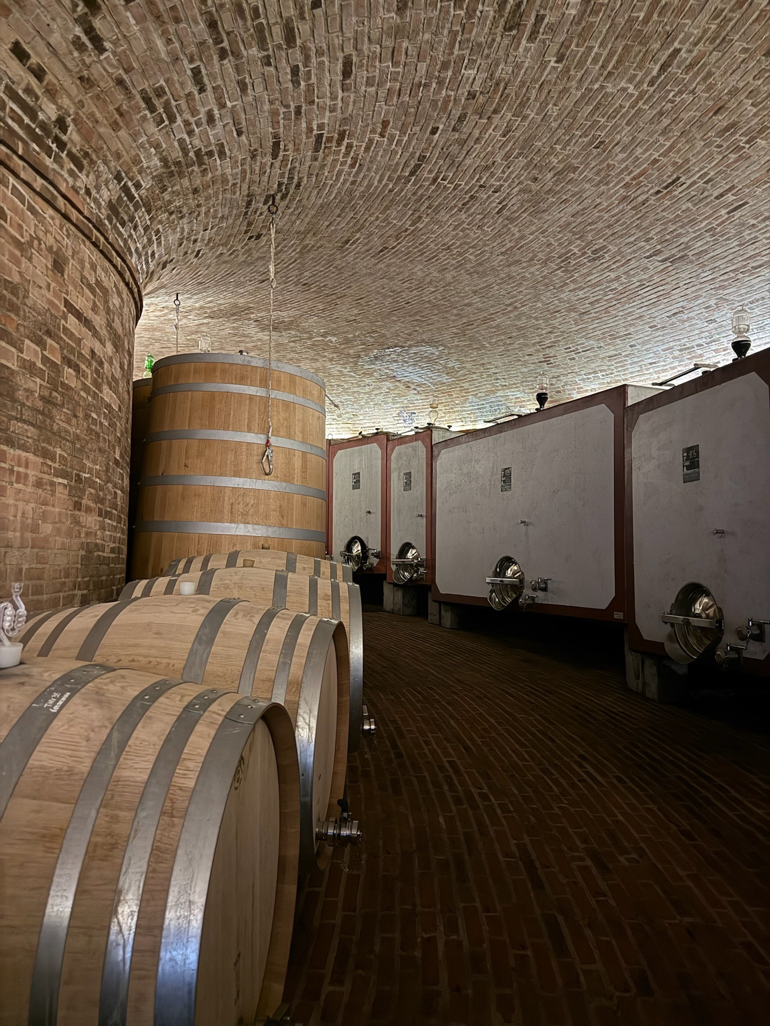Wine barrels beneath a vaulted brick cellar ceiling